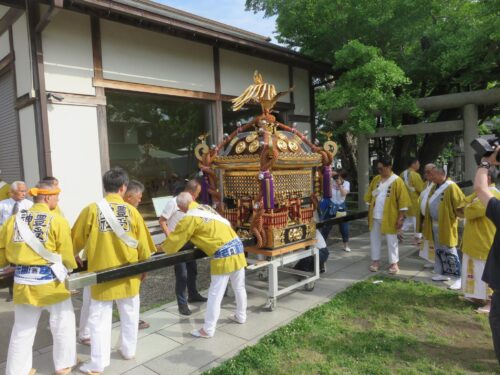 〔式典前の神輿の準備〕 担ぎ棒を挿す作業の様子